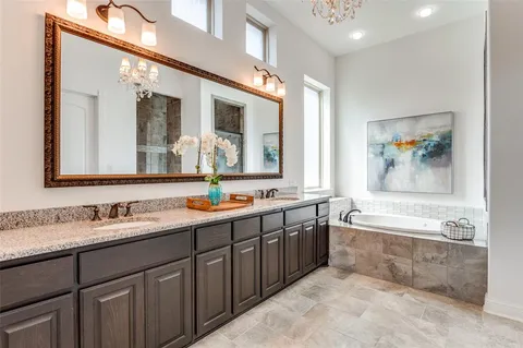 a spacious bathroom with a tub double sink and mirror