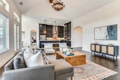 a living room with furniture wooden floor and a dining table