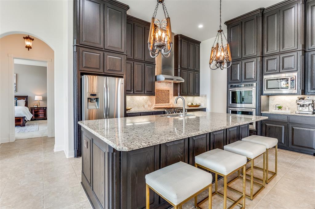 6809 Strauss Colleyville, TX 76034 - Photo 10 of 39 a kitchen with stainless steel appliances granite countertop a sink refrigerator and cabinets