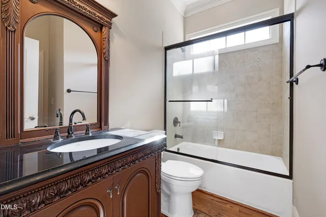 a bathroom with a granite countertop sink mirror vanity and toilet