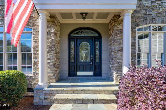 a front view of a house with a front door and potted plants