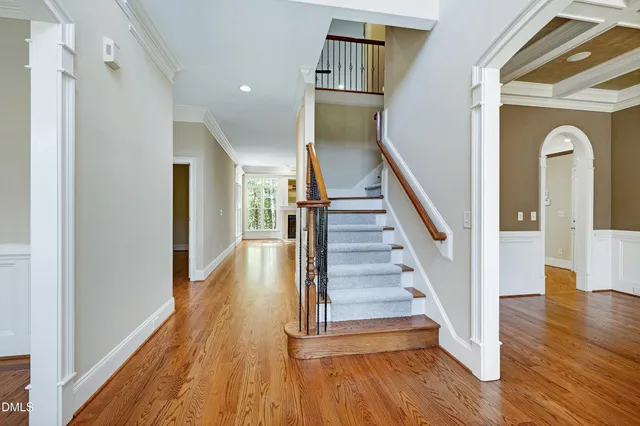 a view of a hallway with wooden floor and staircase