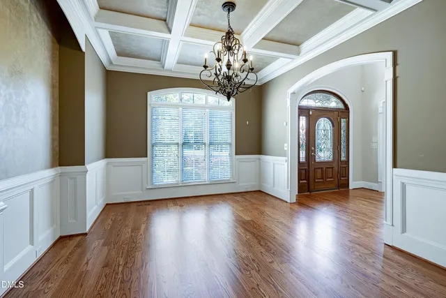 a view of a room with wooden floors and chandelier