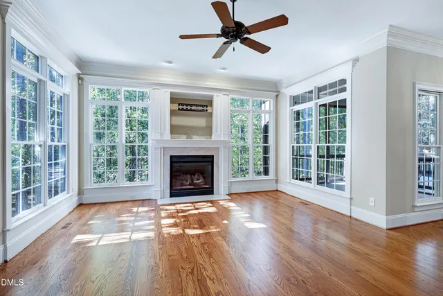 a view of empty room with wooden floor and a fireplace