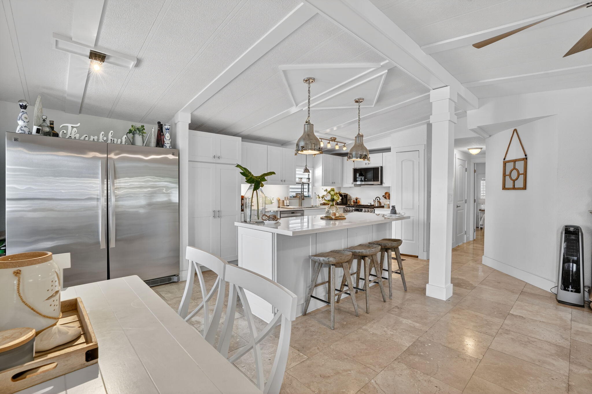 1127 Gulfstream Lane Key Largo, FL 33037 - Photo 7 of 40 a kitchen with stainless steel appliances kitchen island granite countertop a refrigerator a stove a dining table and chairs with wooden floor