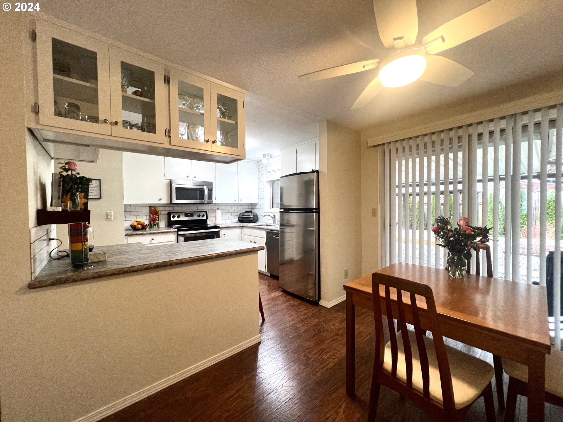 1644 Astor Way Woodburn, OR 97071 - Photo 11 of 28 a kitchen with stainless steel appliances granite countertop a refrigerator a stove a sink a dining table and chairs with wooden floor