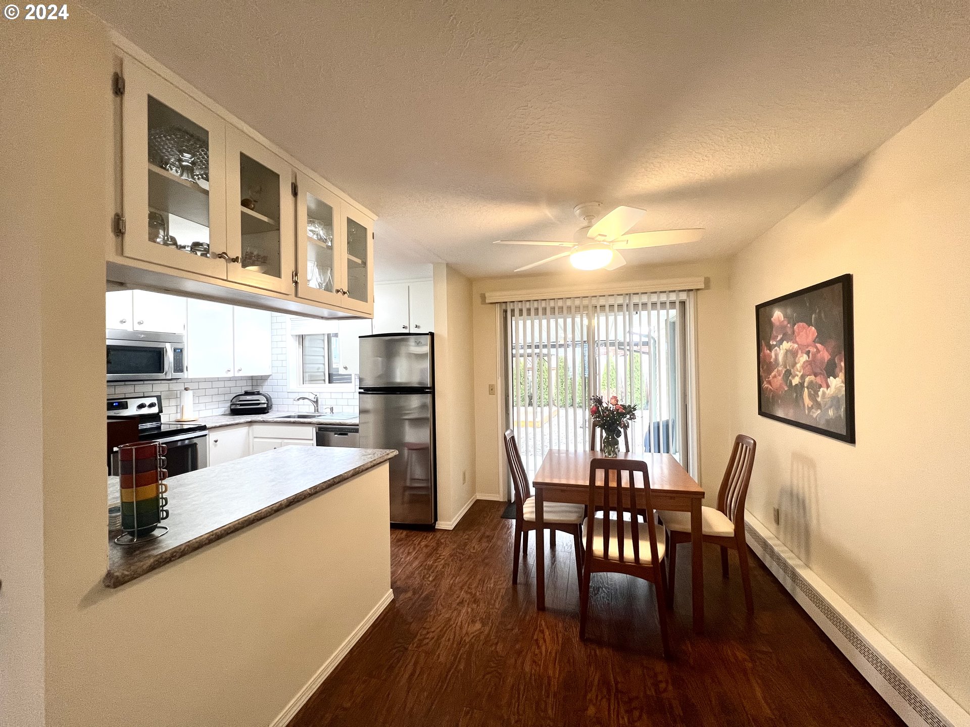 1644 Astor Way Woodburn, OR 97071 - Photo 12 of 28 a kitchen with a dining table chairs and refrigerator