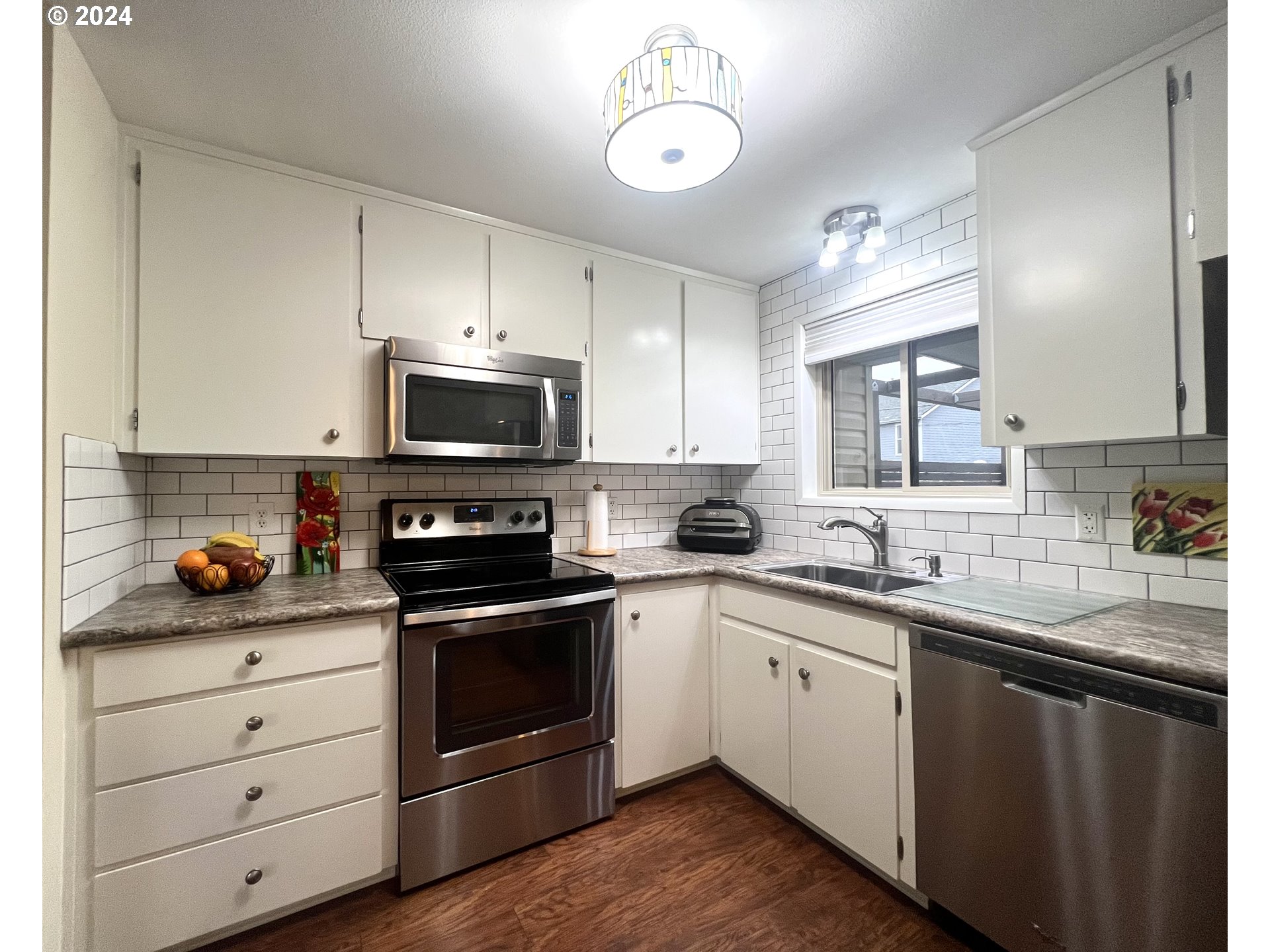 1644 Astor Way Woodburn, OR 97071 - Photo 8 of 28 a kitchen with a sink stove and microwave
