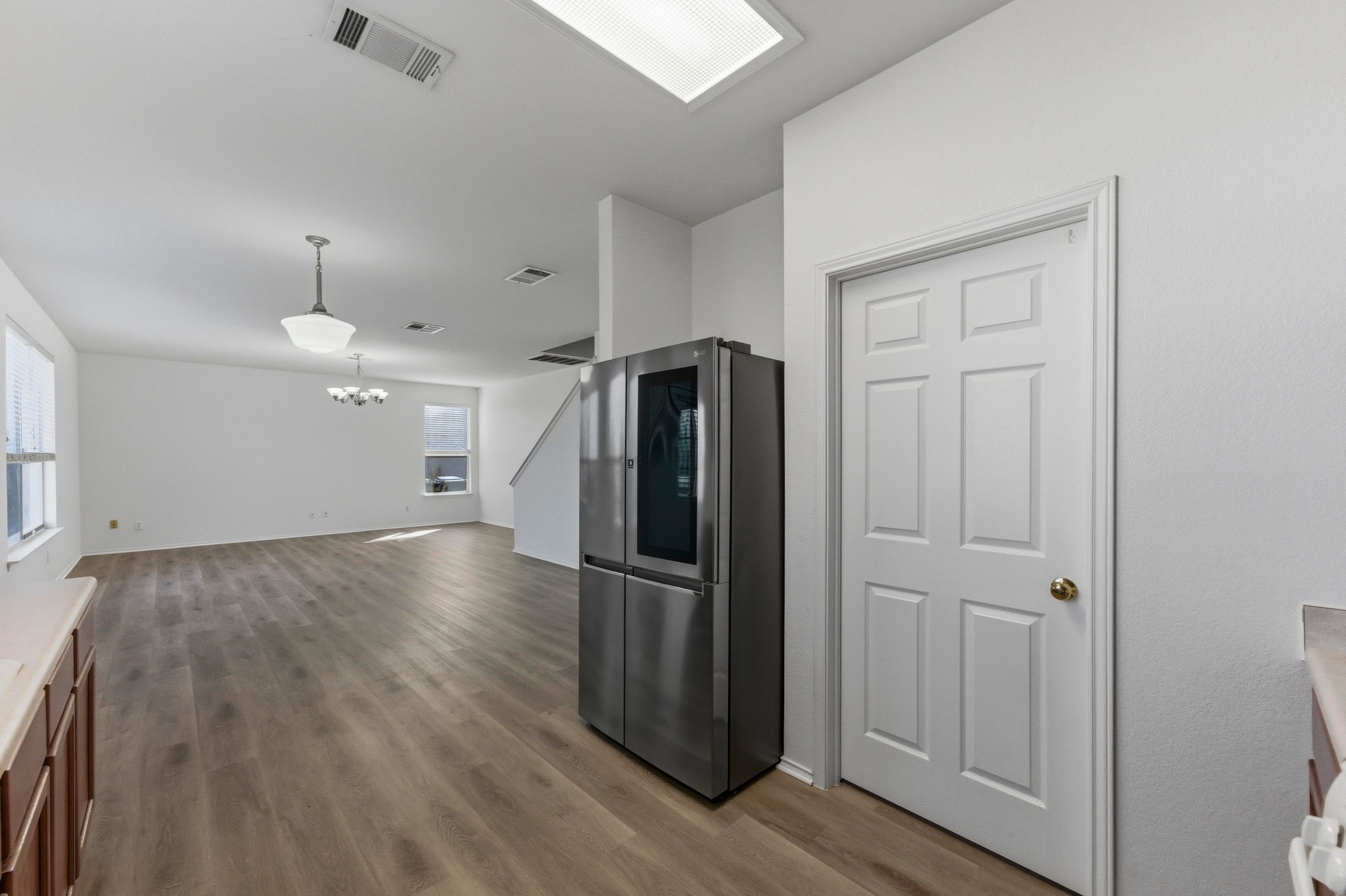 113 Spring Branch Cove Kyle, TX 78640 - Photo 33 of 33 Kitchen with smart refrigerator, light wood-type flooring, open floor plan, light countertops, and hanging lights
