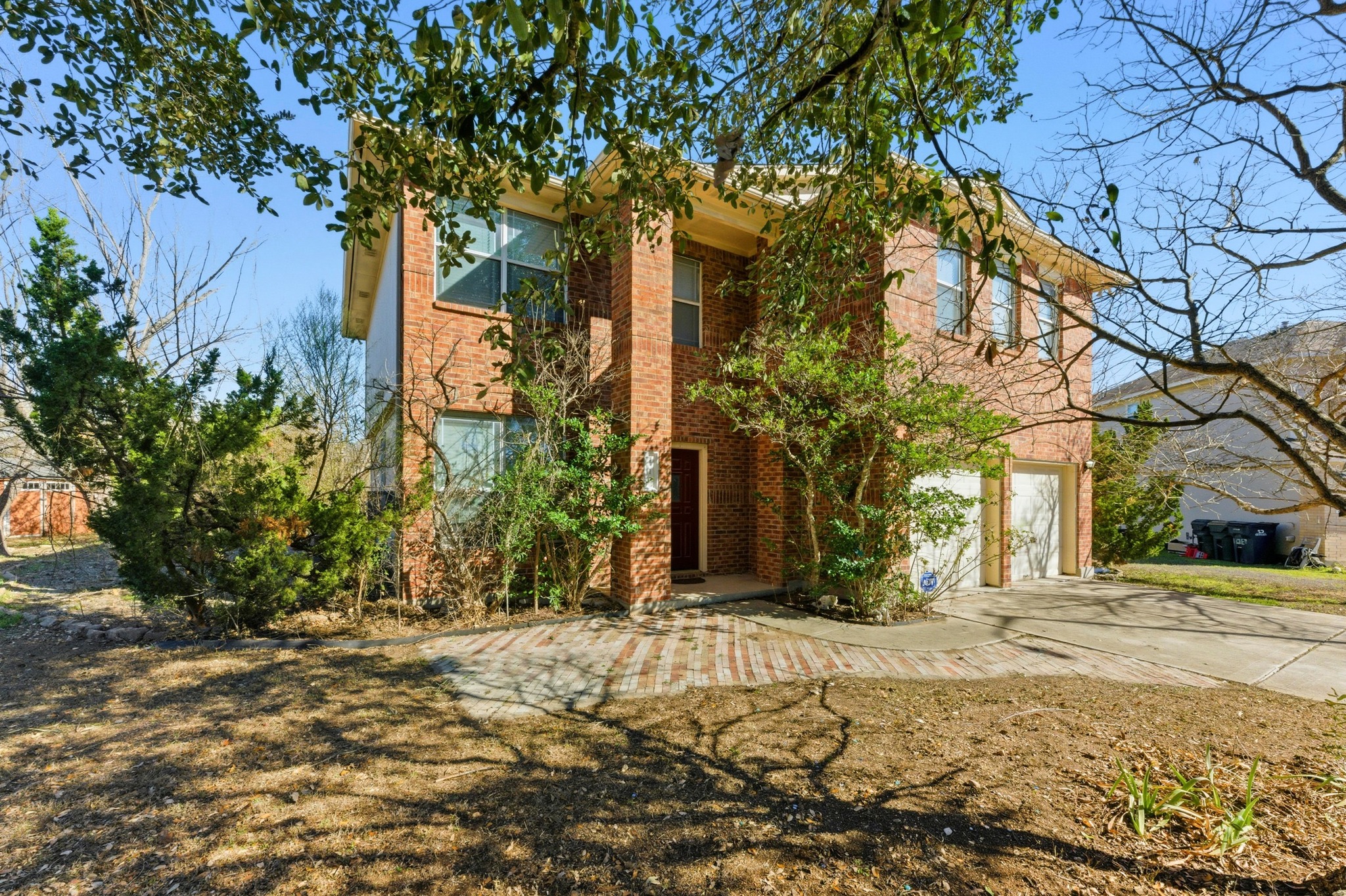 113 Spring Branch Cove Kyle, TX 78640 - Photo 2 of 33 View of front of home featuring concrete driveway, an attached garage, and brick siding