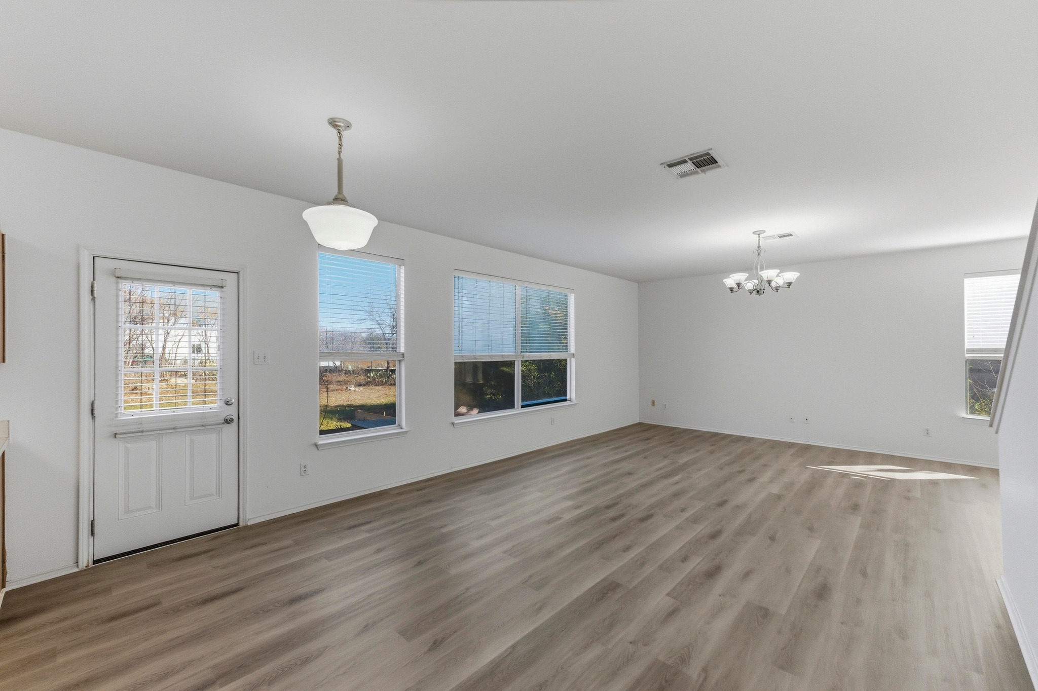 113 Spring Branch Cove Kyle, TX 78640 - Photo 6 of 33 Unfurnished dining area with light wood-style floors and suspended lighting