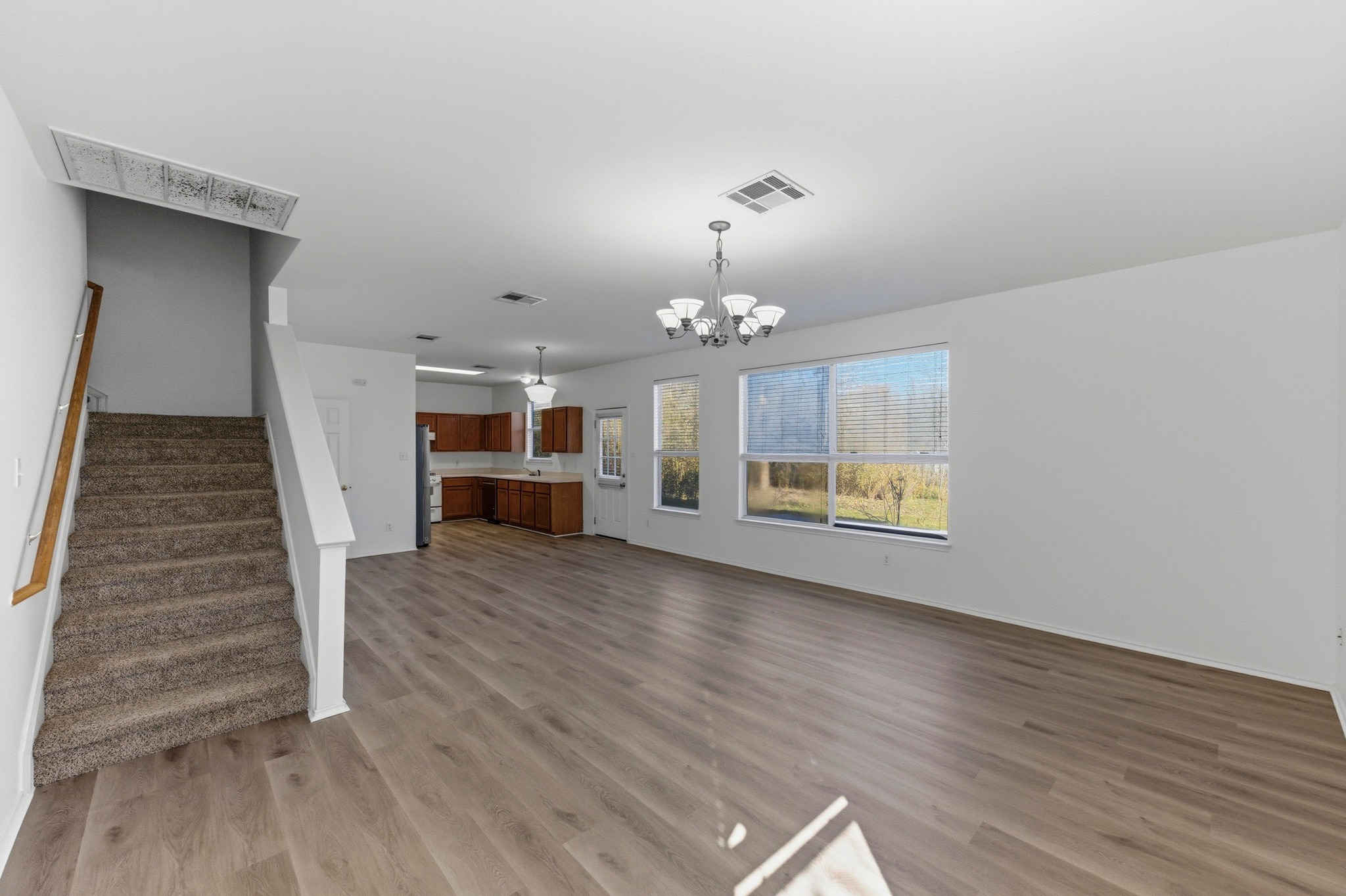 113 Spring Branch Cove Kyle, TX 78640 - Photo 7 of 33 Unfurnished living room featuring hanging lights and light wood-type flooring