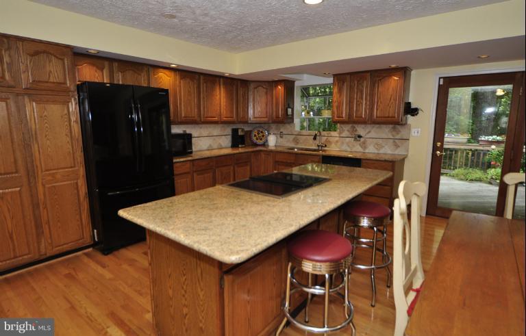 1943 Barton Hill Road Reston, VA 20191 - Photo 1 of 28 a kitchen with stainless steel appliances granite countertop a refrigerator a stove a sink dishwasher with a dining table and chairs