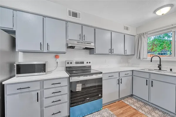 a kitchen with cabinets appliances and a window