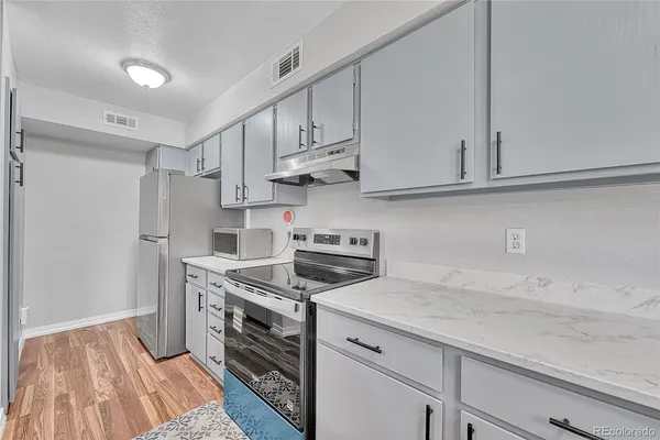 a kitchen with stainless steel appliances granite countertop a sink a stove a refrigerator and cabinets