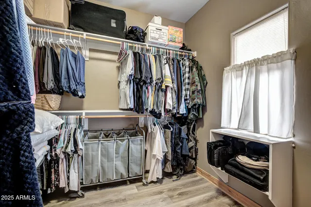 a view of walk in closet with clothes and shoes