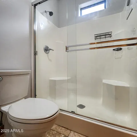 a bathroom with a toilet and a shower