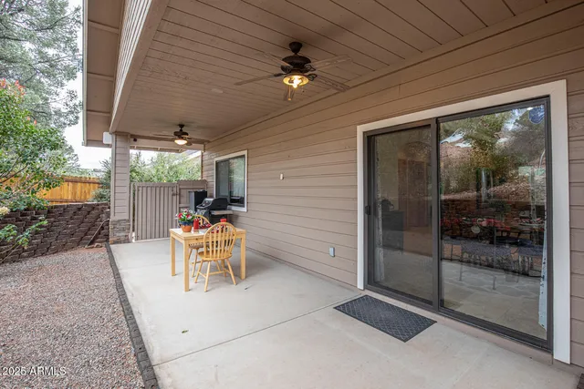 a view of a patio with table and chairs with wooden floor and fence