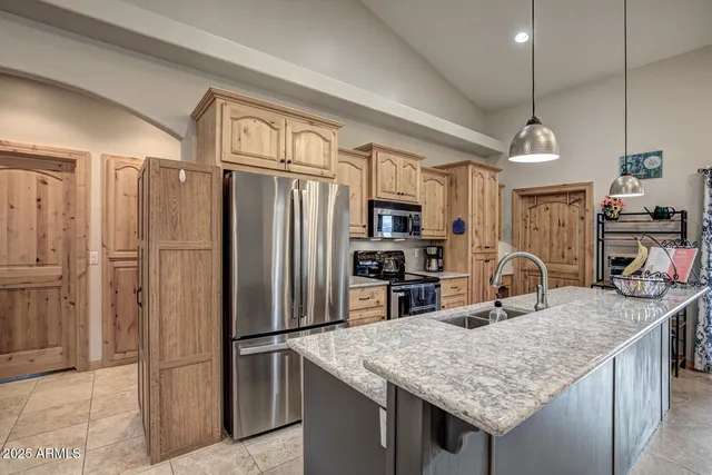 a kitchen with stainless steel appliances granite countertop a sink refrigerator and microwave