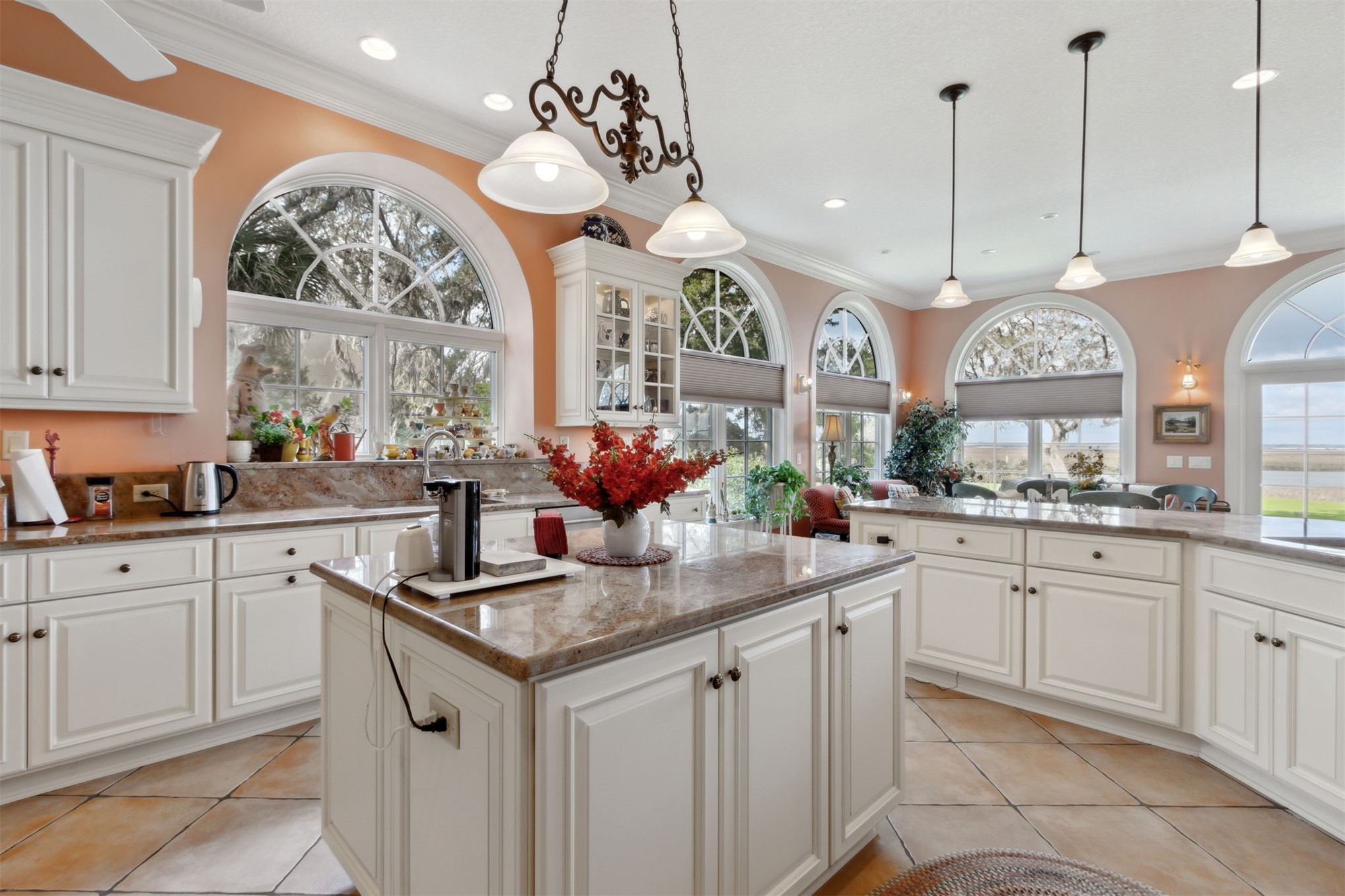 76 Marsh Creek Road Amelia Island, FL 32034 - Photo 19 of 100 a kitchen with kitchen island granite countertop a stove a sink a large island with windows and white walls