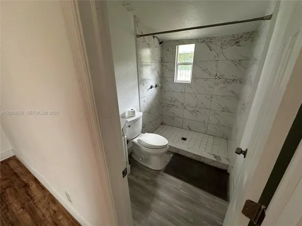 a bathroom with a toilet and a shower