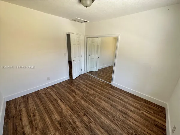 a view of a room with wooden floor