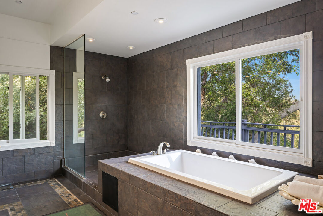 7770 Firenze Avenue Los Angeles, CA 90046 - Photo 15 of 32 a spacious bathroom with a granite countertop tub and a sink