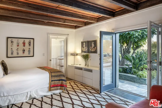 a bedroom with furniture and large windows