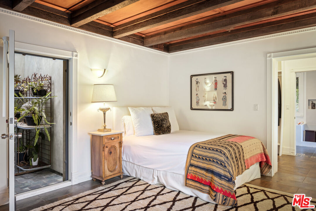 7770 Firenze Avenue Los Angeles, CA 90046 - Photo 19 of 32 a bedroom with a bed and a mirror