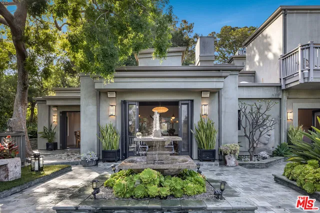 a view of a house with potted plants and a table
