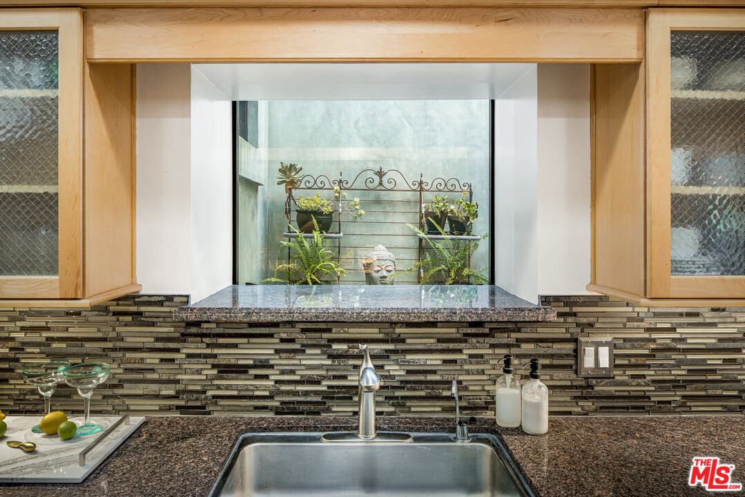 7770 Firenze Avenue Los Angeles, CA 90046 - Photo 10 of 32 a bathroom with a granite countertop sink and a mirror