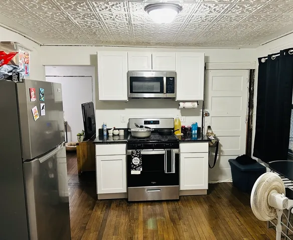 a kitchen with stainless steel appliances granite countertop a stove top oven a refrigerator and a microwave