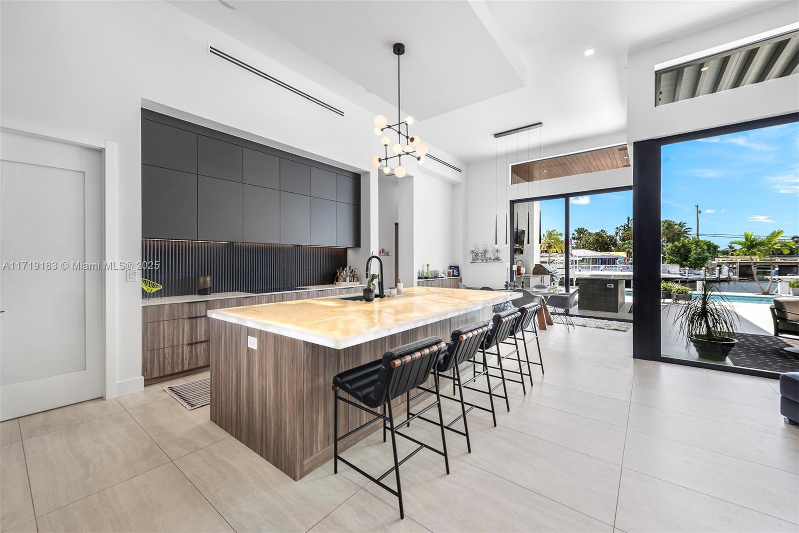 3701 Northeast 26th Avenue Lighthouse Point, FL 33064 - Photo 18 of 65 a kitchen with a stove a refrigerator and a dining table with wooden floor