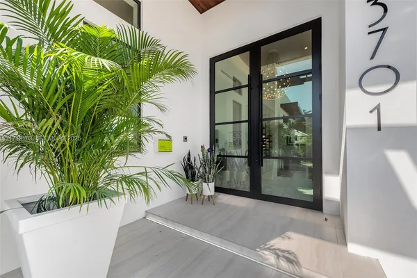 a living room with furniture a rug potted plant and a large window