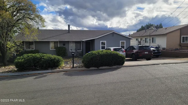 a front view of a house with a garden and plants