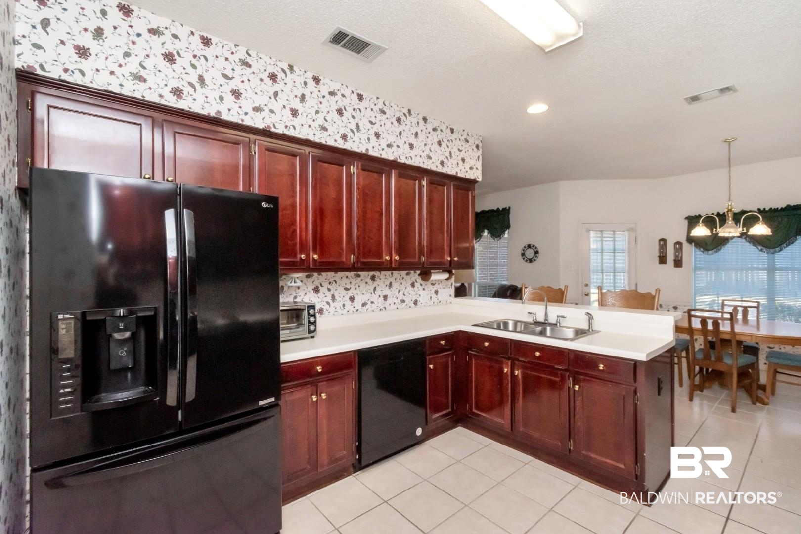 1032 Cross Gates Place Mobile, AL 36609 - Photo 16 of 34 Kitchen featuring black appliances, a peninsula, hanging lights, light countertops, and light tile patterned floors