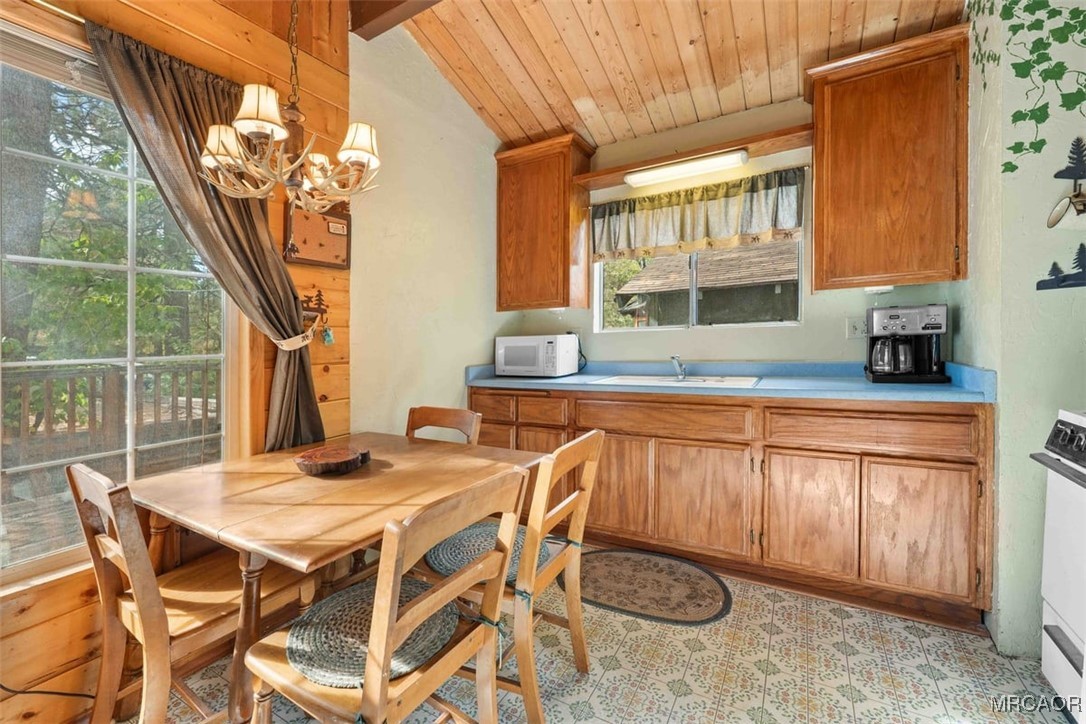 817 Maple Lane Sugarloaf, CA 92386 - Photo 11 of 23 a kitchen with stainless steel appliances granite countertop a sink a stove a dining table and chairs