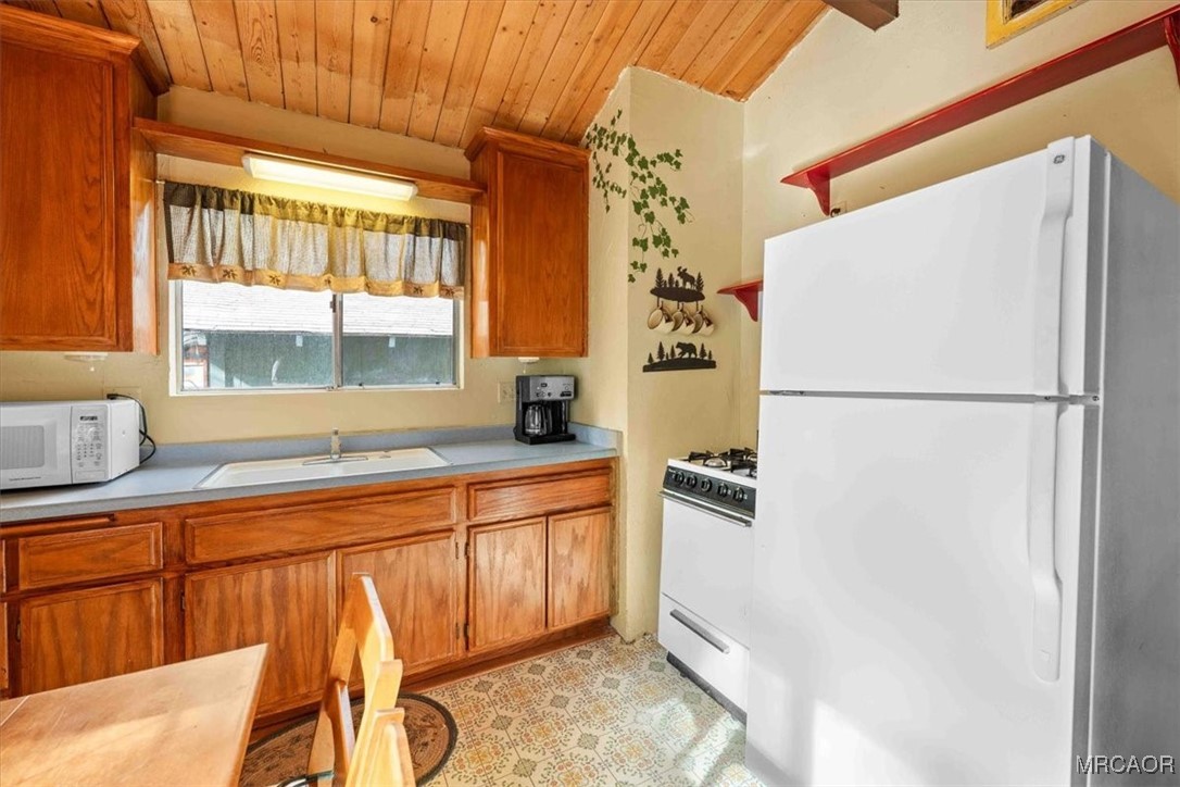 817 Maple Lane Sugarloaf, CA 92386 - Photo 12 of 23 a kitchen with stainless steel appliances granite countertop a refrigerator and a sink