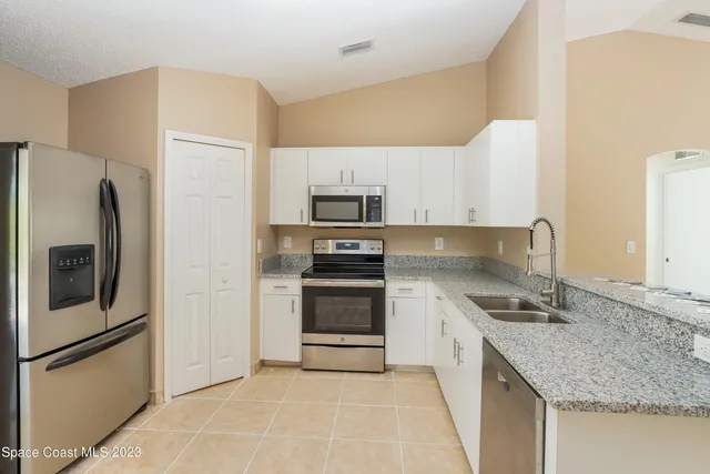 a kitchen with stainless steel appliances granite countertop a refrigerator stove and microwave