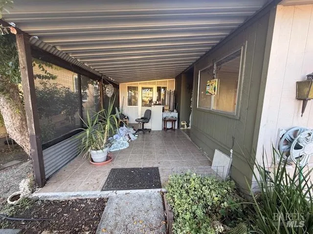 a view of a porch with chairs and potted plants