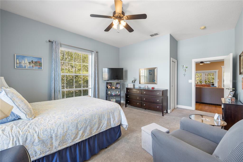 11951 Sheldon Road Tampa, FL 33626 - Photo 24 of 51 a bedroom with a bed a couch and a chandelier