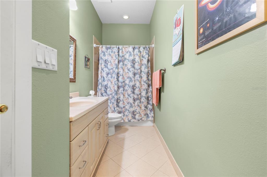 11951 Sheldon Road Tampa, FL 33626 - Photo 31 of 51 a bathroom with a granite countertop sink a mirror and shower