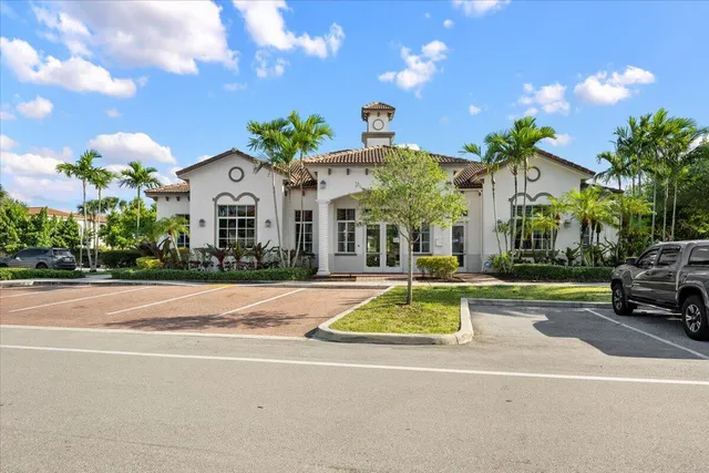 a view of a white house with a swimming pool table and chairs