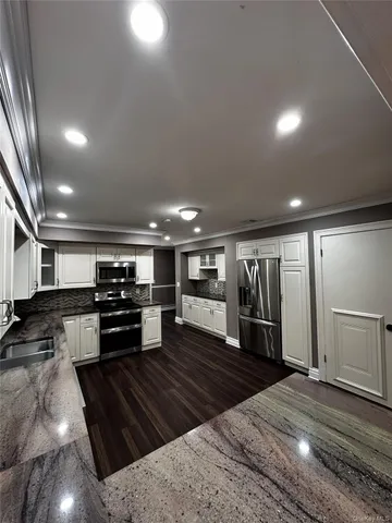 a large kitchen with stainless steel appliances a large counter top