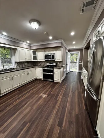 a large kitchen with stainless steel appliances granite countertop a stove and a sink