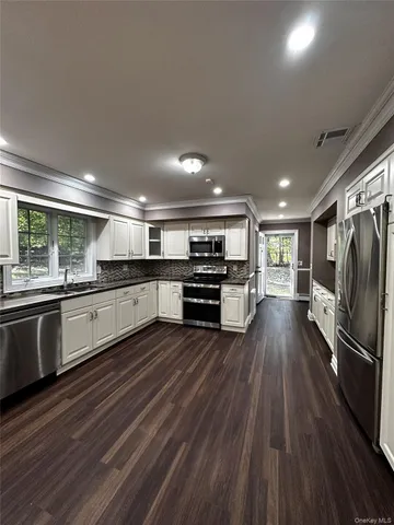 a large kitchen with stainless steel appliances granite countertop a large center island and a stove top oven