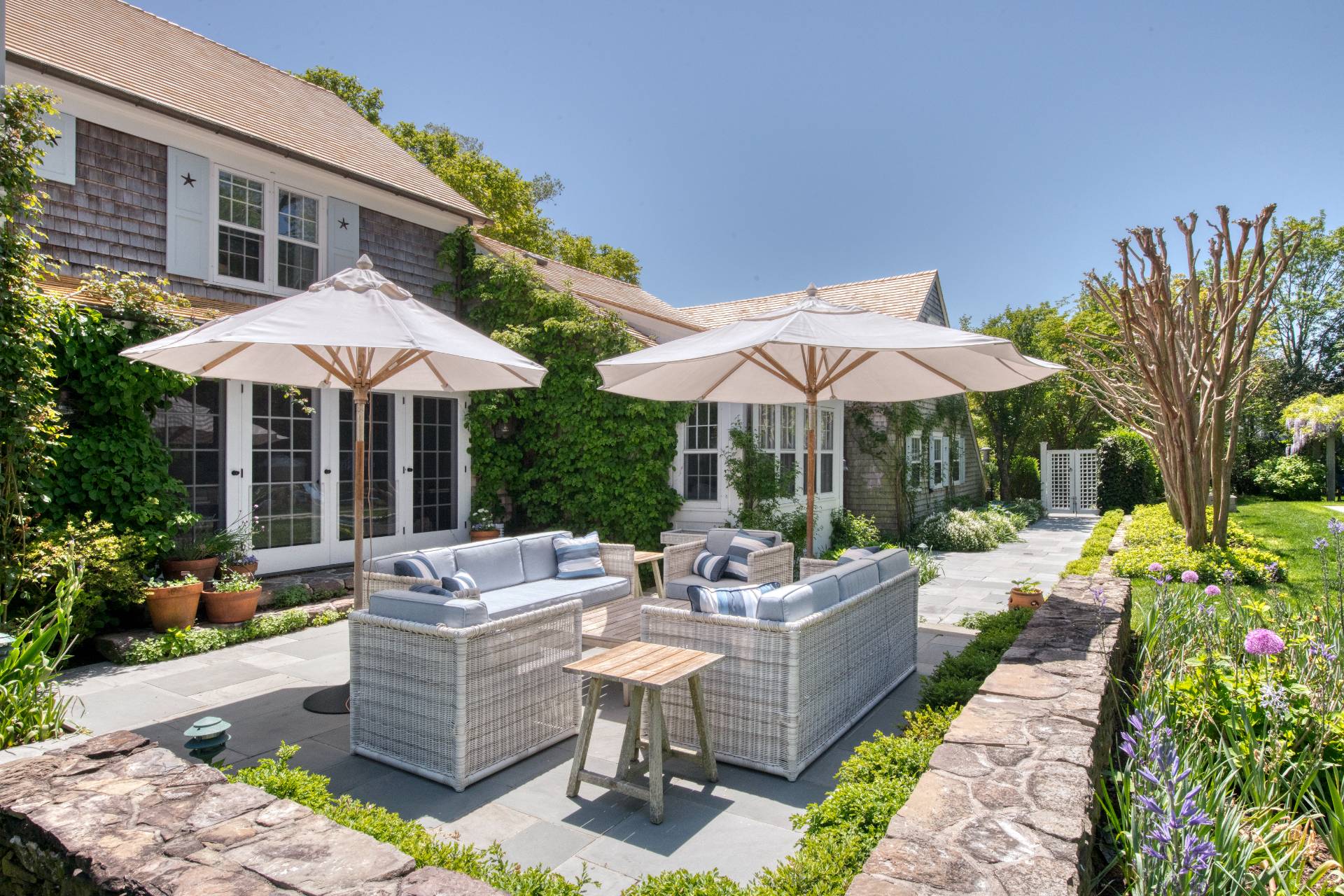 46 Westminster Road Water Mill, NY 11976 - Photo 21 of 28 a view of a patio with chairs and table under an umbrella with a garden