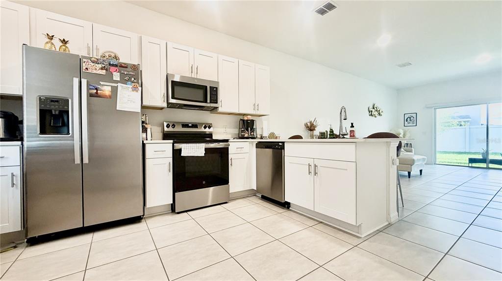 3244 Skyline Loop Kissimmee, FL 34758 - Photo 2 of 13 a kitchen with stainless steel appliances granite countertop a stove a sink and a refrigerator