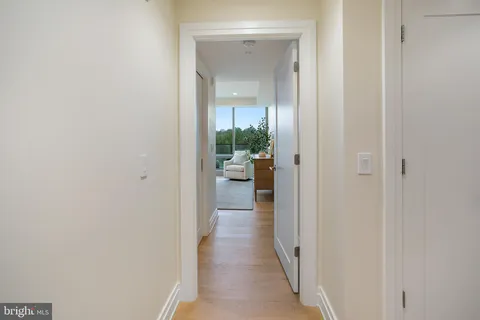 a view of a hallway with wooden floor and a living room