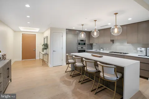 a kitchen with kitchen island a dining table chairs sink and stove